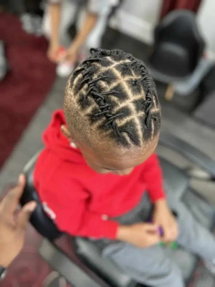 A child's starter locs set in a precise diamond part pattern.