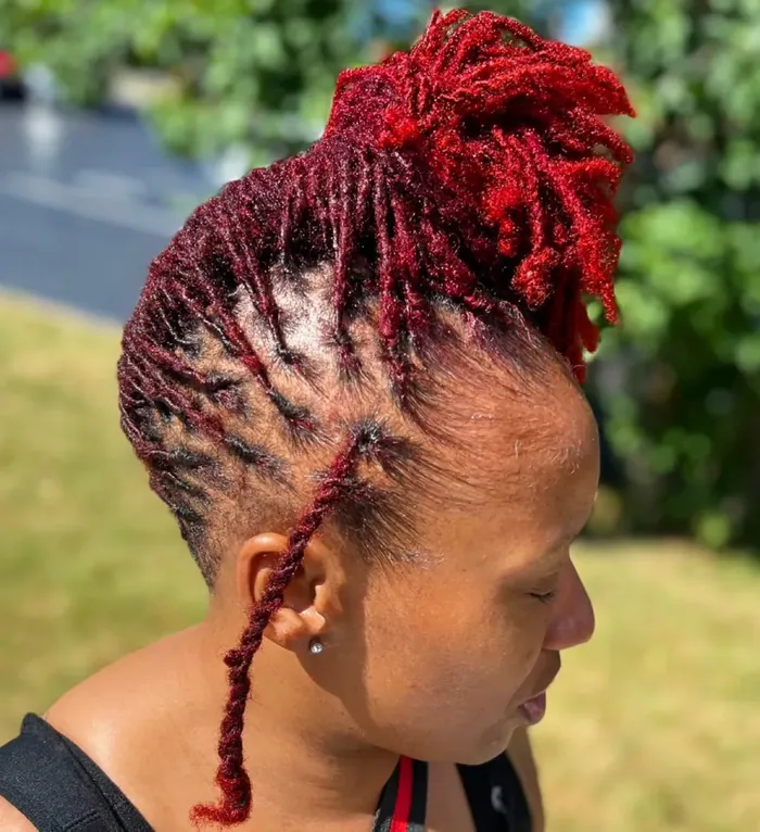 Red-toned locs retwisted and gathered into a detailed high style.