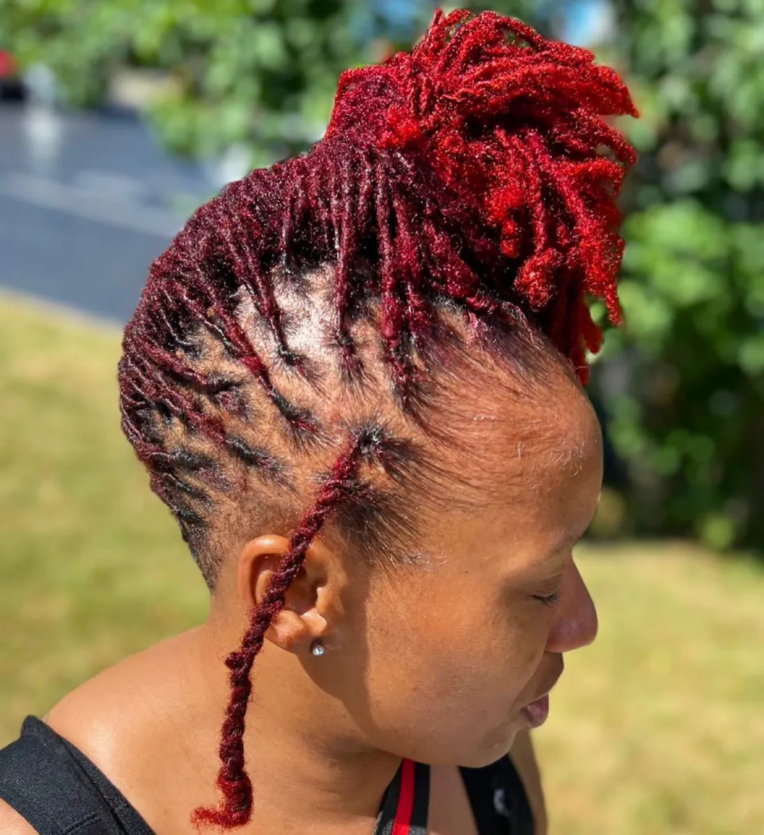 Red-toned locs retwisted and gathered into a detailed high style.