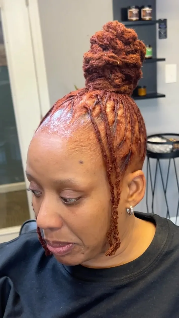 Locs colored a warm auburn copper and gathered into a bun.